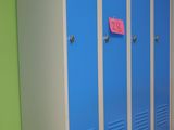 a row of blue lockers in a room with green walls