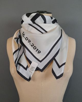 foulard carré noir et blanc sur un buste de mannequin muni d'une étiquette nominative