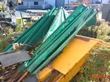 une pile de parapluies verts posée sur une pile de machines jaunes
