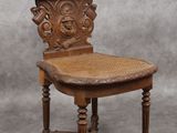une vieille chaise en bois avec une assise en osier, sur fond gris