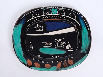 une assiette noire et verte sur laquelle est peinte une image