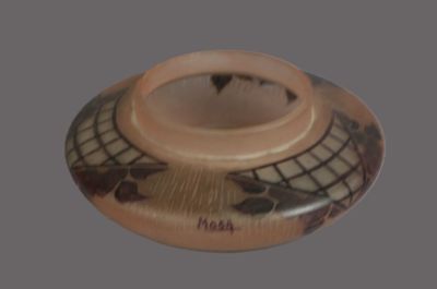 a small vase with a design on it on a gray background