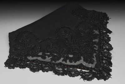 de la dentelle noire sur un tissu noir posé sur une surface blanche