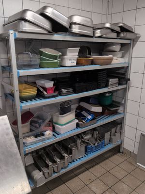 many pans and pans on the shelves in the kitchen