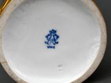 a close up of a blue and white vase on a table