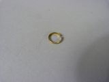 gros plan d'une bague en or sur une surface blanche