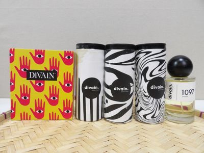 three bottles of perfume sitting on top of a table next to a box