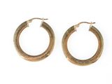une paire de boucles d'oreilles en or sur fond blanc
