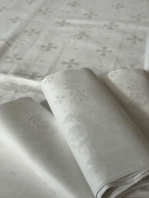trois serviettes pliées posées sur une table recouverte d'une nappe blanche