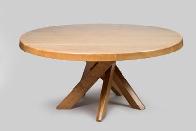 un gros plan d'une table en bois à trois pieds avec un plateau rond