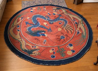 un tapis posé à même le sol, orné d'un motif représentant un dragon