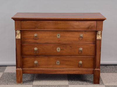 une commode en bois posée sur un sol en damier, dans une pièce