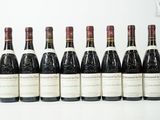 six bouteilles de vin sont alignées sur une table