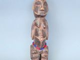 une petite statue en bois représentant un homme coiffé d'un chapeau