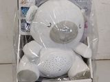 un ours en peluche blanc posé dans une boîte par terre