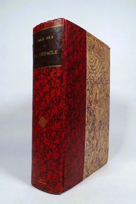 an old book sitting on top of a white table next to a white wall