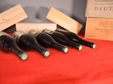 several bottles of wine are lined up on a red table