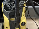 un presseur jaune et noir posé par terre à côté d'une machine rouge et verte