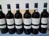 six bouteilles de vin sont alignées sur une table