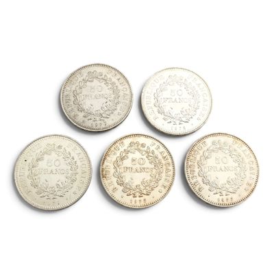 six types différents de pièces d'argent sur une surface blanche