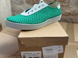 pair of green and white polka dot sneakers on top of a cardboard box