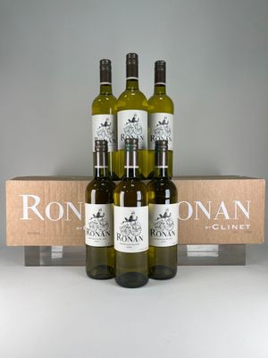 four bottles of wine in a wooden crate with a box behind them