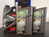 three bottles of motor oil sitting on top of a table next to each other