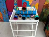 une petite table sur laquelle sont posés plusieurs rouleaux de papier toilette