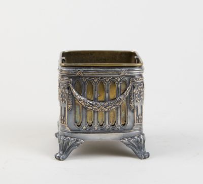an antique silver metal planter with ornate design on a white background