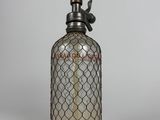une bouteille en verre à l'ancienne, surmontée d'un oiseau