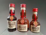 three bottles of liquor sitting on top of a table next to each other
