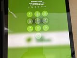 a tablet with a green button on it sitting on a table