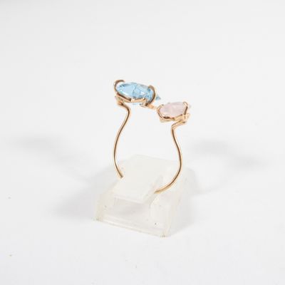 a close up of a gold ring with two blue and pink stones on it