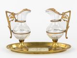 une paire de cruches anciennes en verre et plaquées or, posées sur un plateau