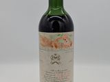 une bouteille de vin rouge posée sur une table blanche