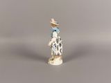 a small figurine of a woman with a hat and dress