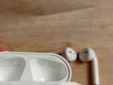 a person holding a pair of airpods in their hand