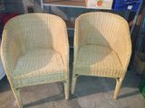 paire de fauteuils en osier avec des accoudoirs et des pieds en forme de chaise