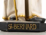 statue of saint bernard holding a staff and a book