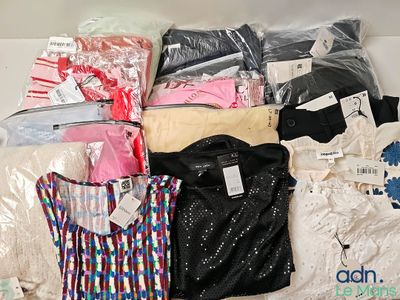 beaucoup de vêtements posés sur un lit