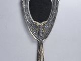 un miroir ancien en argent orné d'une pierre bleue au centre