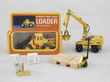 a toy truck with a loader in front of a box