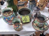 de nombreux vases et tasses posés sur une table, accompagnés d'une étiquette de prix