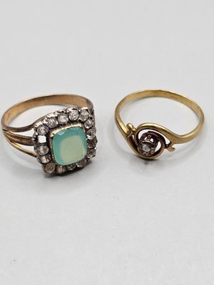 two rings, one with a green stone and the other with diamonds