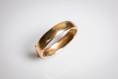 gros plan d'une bague en or sur une surface blanche