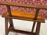 a wooden bench that is sitting in front of a red wall