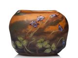 un vase en verre sur lequel sont peintes des fleurs sur un fond blanc