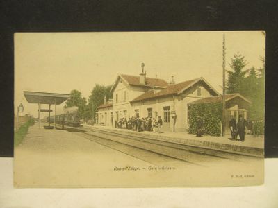 une vieille photo d'une gare où l'on voit des gens debout sur le quai