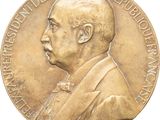 une vieille médaille en or sur laquelle figure le portrait d'un homme en costume