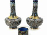 pair of blue and gold vases sitting next to each other on a white surface